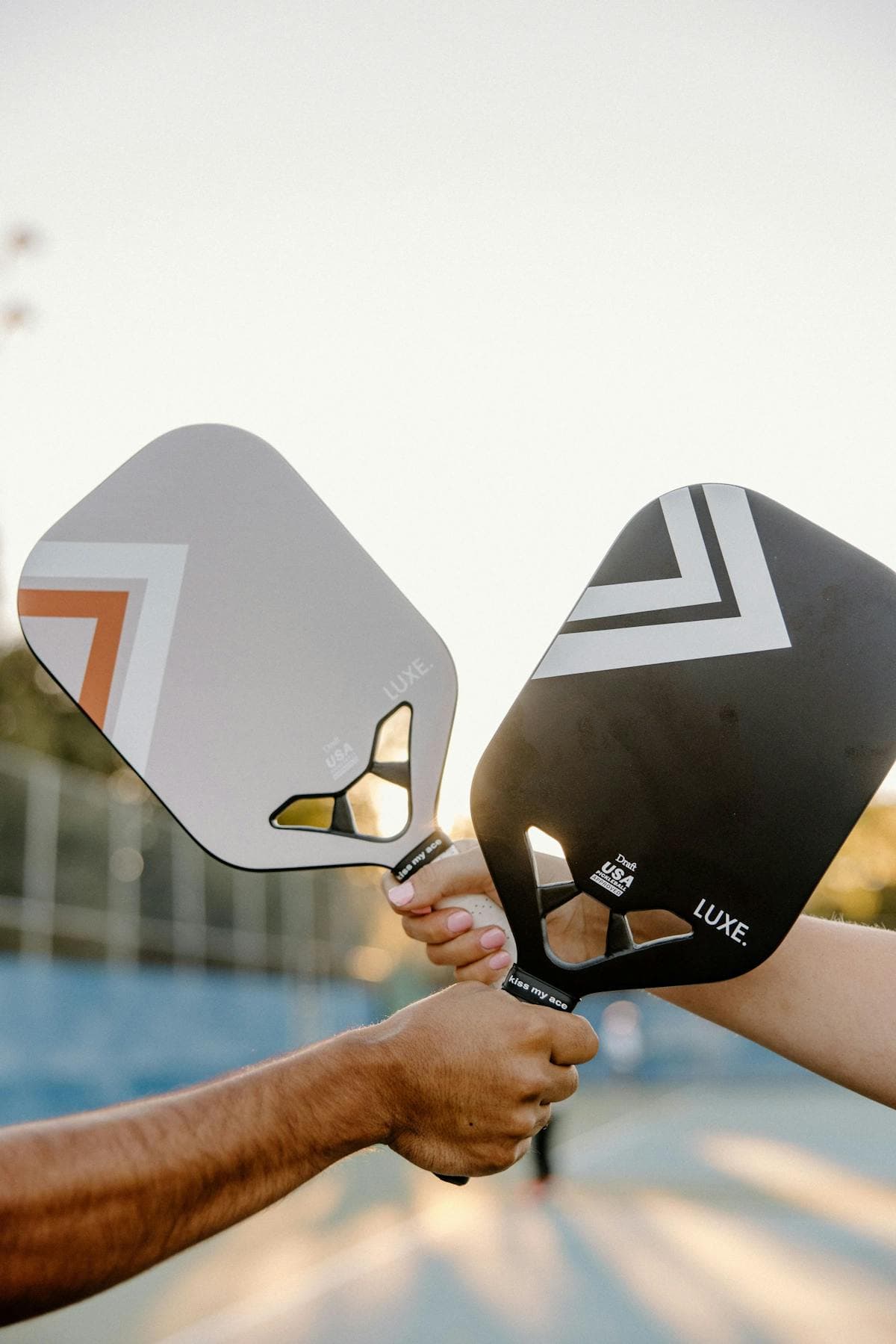 Two pickleball paddles compared side by side on court